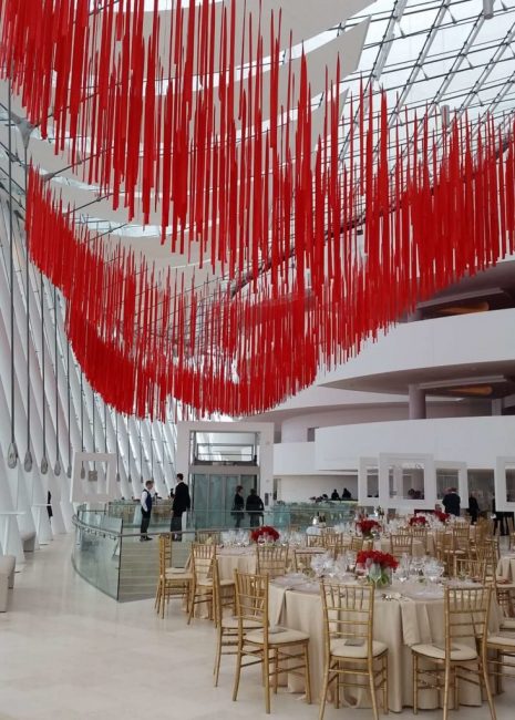 A beautifully decorated dinner event hall with red ceiling decorations, showcasing elegant special event rentals for corporate gatherings in Kansas City